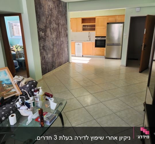 חדר עם מטבח וכלי ניקוי על שולחן זכוכית
